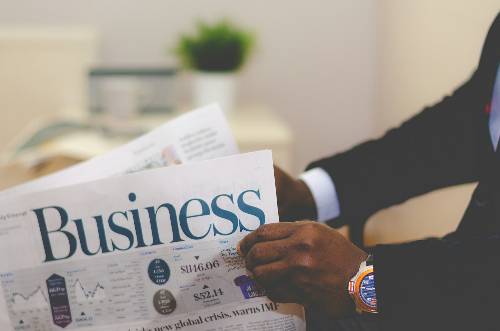 business consultant wearing suit reading business newspaper