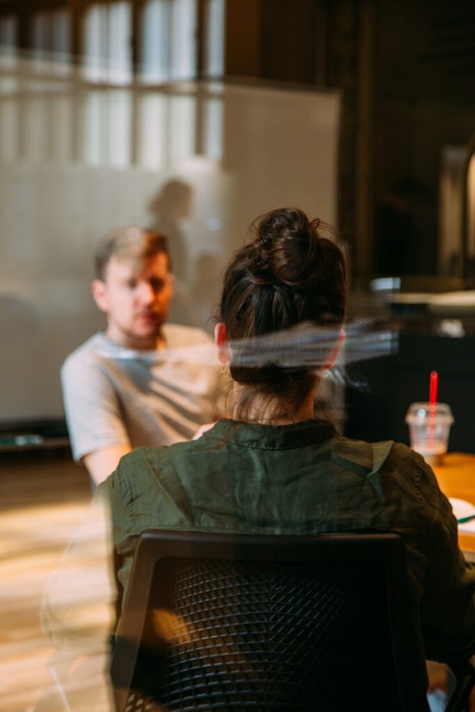 person sitting in a chair in front of a man with receiving coaching