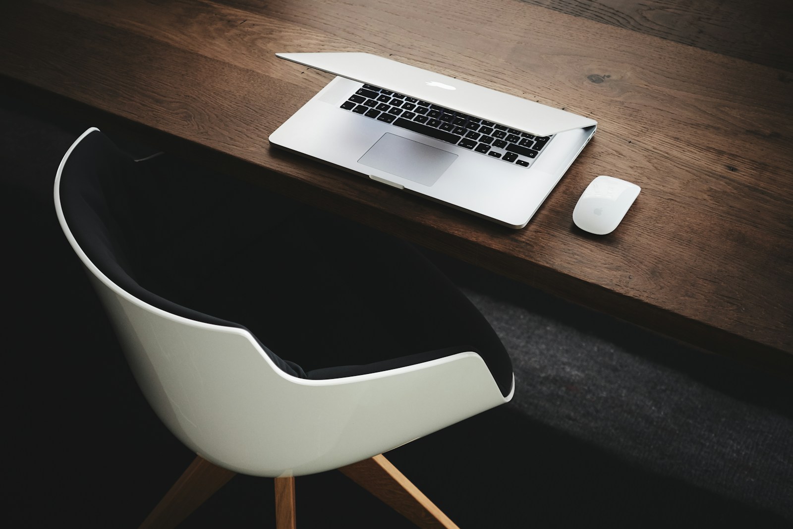 Apple MacBook beside computer mouse on table, desk for coaching